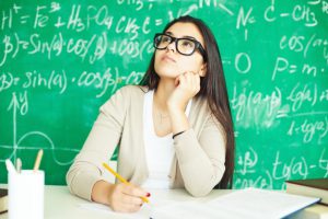 Girl in a classroom setting lost in deep thought.